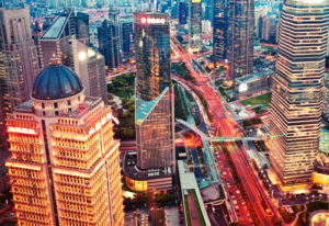 An overhead photo of Shanghai showing brightly-lit buildings and streets